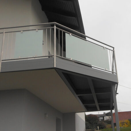 Moderner Balkon mit milchglasverkleidung und Metallgeländer an einem Wohnhaus, draußen bei Tageslicht. HANSEL.kraus metalltechnik gmbh