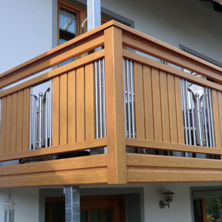 Moderner Holzbalkon mit senkrechten Edelstahl-Elementen an einem Wohnhaus, Tageslicht, Außenansicht. HANSEL.kraus metalltechnik gmbh