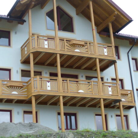 Mehrstöckiges Haus mit Holz-Balkonen und großen Fenstern, moderner Alpenstil. HANSEL.kraus metalltechnik gmbh