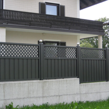 Moderner Gartenzaun aus Metall vor einem weißen Haus mit Balkon und Fenster. HANSEL.kraus metalltechnik gmbh