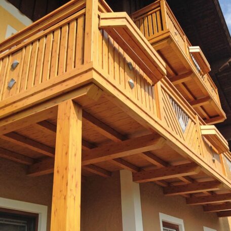 Solider Holz-Balkon mit Verzierungen an einem Gebäude, Perspektive von unten fotografiert. HANSEL.kraus metalltechnik gmbh