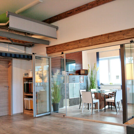 Modernes Besprechungszimmer mit Glastrennwand, Holzbalken und natürlichem Tageslicht in zeitgemäßem Büro. HANSEL.kraus metalltechnik gmbh