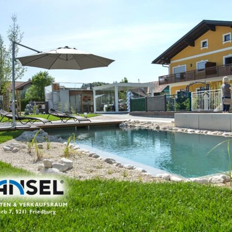 Naturpool im Garten vor modernem Einfamilienhaus, Sonnenschirm und Terrasse im Hintergrund. HANSEL.kraus metalltechnik gmbh