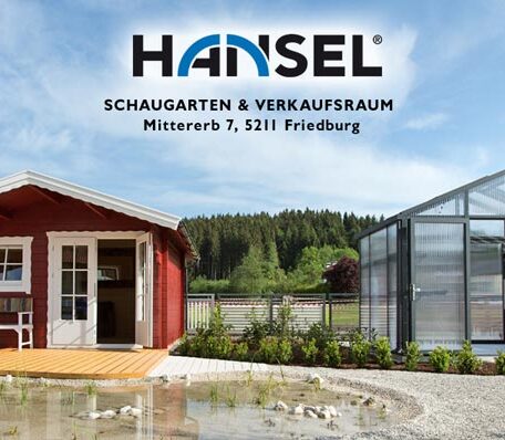 Rotes Gartenhaus und modernes Gewächshaus mit Firmenschild Hansel im Schaugarten in Freiburg. de HANSEL.kraus metalltechnik gmbh