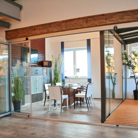 Modernes Esszimmer mit Glastrennwänden, Holzbalken und viel Tageslicht, stilvoll eingerichtet. HANSEL.kraus metalltechnik gmbh