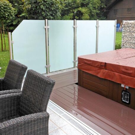 Sichtschutz aus Milchglas trennt Whirlpool-Bereich auf Terrasse von grünem Gartenbereich ab. HANSEL.kraus metalltechnik gmbh