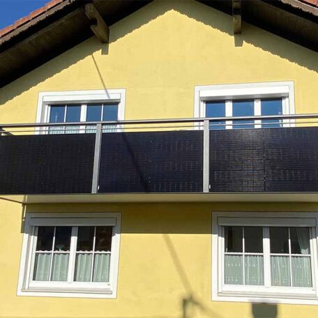 Gelbes Haus mit vier weißen Fenstern und einem Balkon mit dunkler Verkleidung. HANSEL.kraus metalltechnik gmbh