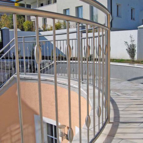 Barrierefreie Rampe mit Metallgeländer vor modernem Gebäude bei sonnigem Wetter, Fokus auf Architekturdetails. HANSEL.kraus metalltechnik gmbh