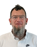 Porträt eines Mannes mit Brille, Bart und Piercings vor weißem Hintergrund. HANSEL.kraus metalltechnik gmbh