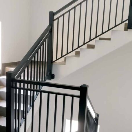 Treppenhaus mit schwarzem Metallgeländer und weißen Wänden, modernes Design mit Tageslichteinfall. HANSEL.kraus metalltechnik gmbh