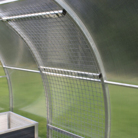 Gewächshaus-Detailaufnahme mit beschichtetem Metallrahmen und transparentem Wellkunststoff, grüner Rasen im Hintergrund. HANSEL.kraus metalltechnik gmbh