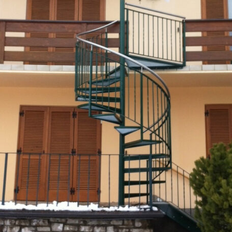 Außentreppe aus Metall in Wendelform vor Balkon und geschlossenen Fensterläden. HANSEL.kraus metalltechnik gmbh