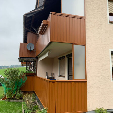 Mehrgeschossiger Balkon mit braunen Paneelen, angrenzender Garten und Blick ins Grüne. de HANSEL.kraus metalltechnik gmbh