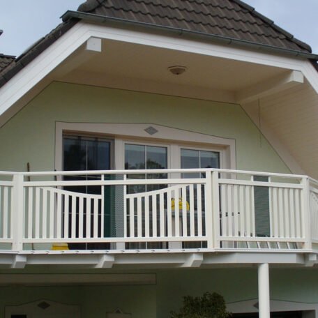Moderner Balkon mit weißem Geländer an einem Einfamilienhaus unter schrägem Dach. HANSEL.kraus metalltechnik gmbh