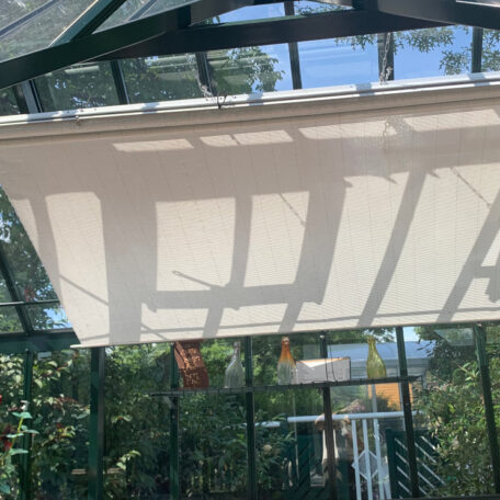 Innenansicht eines Gewächshauses mit heller Beschattung, Sonnenlicht fällt durch das Glasdach. HANSEL.kraus metalltechnik gmbh