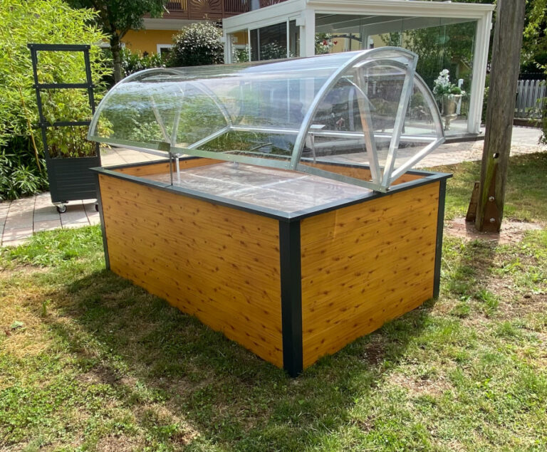 Hochbeet mit transparenter Abdeckung steht im Garten auf einer Rasenfläche. HANSEL.kraus metalltechnik gmbh