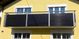 Gelbes Haus mit vier weißen Fenstern und einem Balkon mit dunkler Verkleidung. HANSEL.kraus metalltechnik gmbh