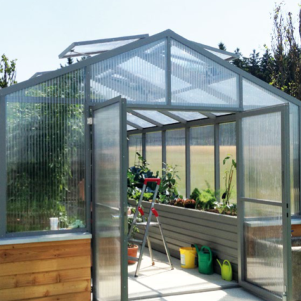 Modernes Gewächshaus mit offenen Türen, grünen Pflanzen und Gartenzubehör, sonniger Tag. HANSEL.kraus metalltechnik gmbh