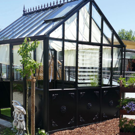 Modernes, schwarzes Gewächshaus im Garten mit Glasdach und umgebender Bepflanzung. de HANSEL.kraus metalltechnik gmbh