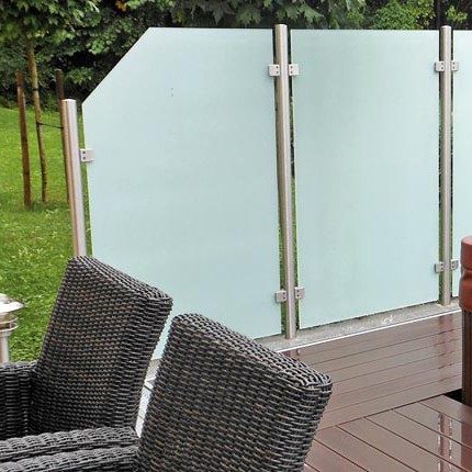 Mattenstühle auf Holzterrasse, dahinter Sichtschutz aus Milchglas, grüner Garten im Hintergrund. HANSEL.kraus metalltechnik gmbh